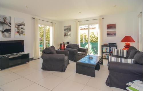 a living room with couches and a flat screen tv at Cozy Home In Aigues-Mortes With Kitchen in Aigues-Mortes