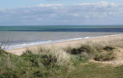 a sandy beach with the ocean in the background at Gorgeous Home In St Marcouf De L'isle in Saint-Marcouf