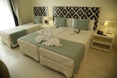 a hotel room with two beds with flowers on them at Al Mandari Hôtel Tétouan in Tetouan