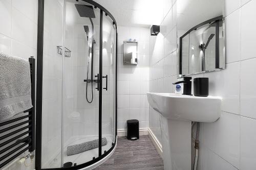 a white bathroom with a shower and a sink at Private Room with En-suite, City Centre With Free On Site Parking in Hereford