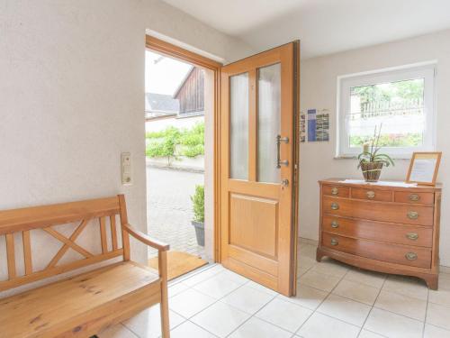 マンダーシャイトにあるComfortable holiday home Manderscheid with gardenの木製のドアと木製のドレッサーが備わる客室です。