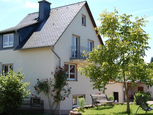 a white house with a bench in front of it at Comfortable holiday home Manderscheid with garden in Manderscheid