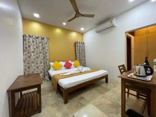 una camera da letto con un letto, un tavolo e una televisione di Ola Agro Riverside Villa in Malvan, Dhamapur, Sindhudurg a Pendur