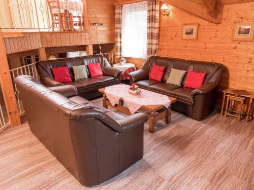 una sala de estar con 2 sofás de cuero y una mesa. en Holiday home in Lossburg near the ski area en Loßburg