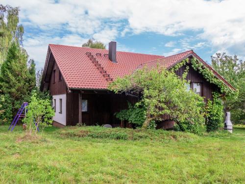 a house with a red roof on a green field at Holiday home in Lossburg near the ski area in Loßburg