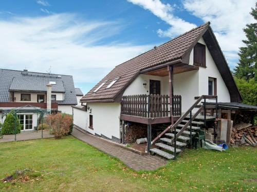 ein weißes Haus mit einer Veranda und einer Terrasse in der Unterkunft Holiday home near the Klingenthal ski resort in Beerheide