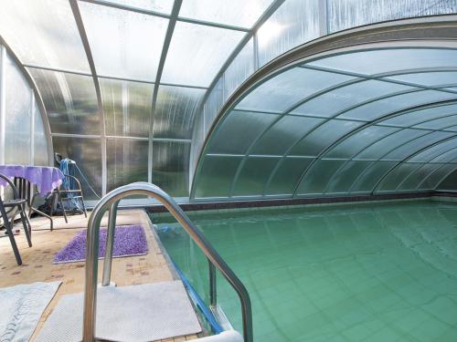 an indoor swimming pool with a glass ceiling at Holiday home near the Klingenthal ski resort in Beerheide