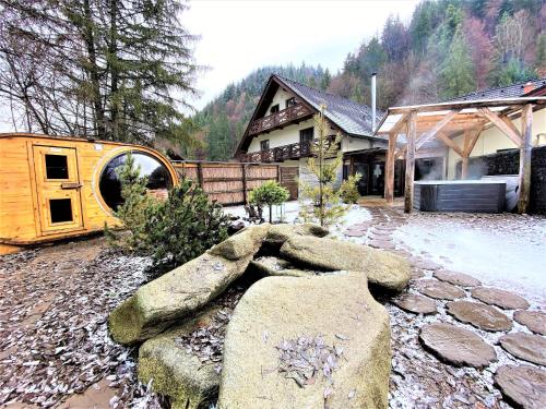 a house with a stone path in front of a building at Penzion Bystrinka in Tale