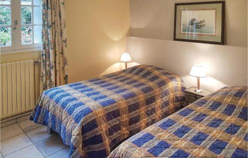 two beds in a room with two lamps on tables at 2 Bedroom Amazing Home In Locronan in Locronan