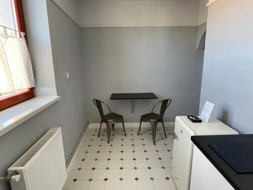 a small kitchen with two chairs and a table at Allegro apartments city center in Oradea