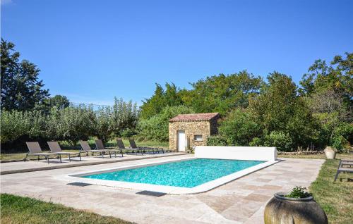 einen Pool in einem Garten mit Stühlen und einem Gebäude in der Unterkunft Lovely Home In St Quentin La Poterie With Private Swimming Pool, Can Be Inside Or Outside in Saint-Quentin-la-Poterie