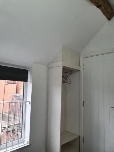 a white room with a shelf and a window at The Wheatsheaf Inn in Atherstone