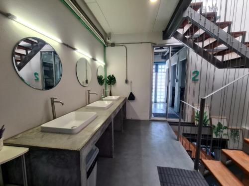 a bathroom with two sinks and a large mirror at Hybrit hostel&cafe in Hat Yai