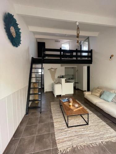 un salon avec un lit mezzanine et un canapé dans l'établissement LA MANOSC, à Grimaud