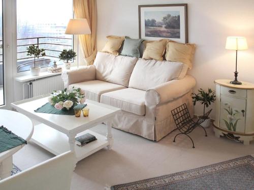 un soggiorno con divano bianco e tavolo di Flat in Gl cksburg with sea view a Ulstrupfeld