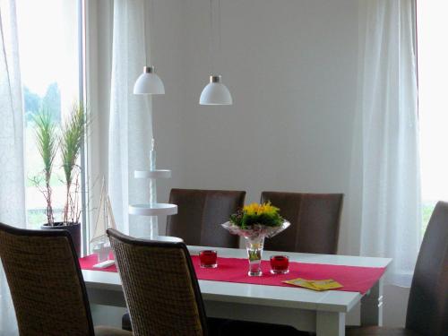Un comedor con una mesa y sillas rojas. en Ferienhaus in der Lüneburger Heide, en Wietzendorf