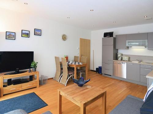 a living room with a television and a kitchen at Modern Apartment near Forest in Heinrichskirchen in Heinrichskirchen