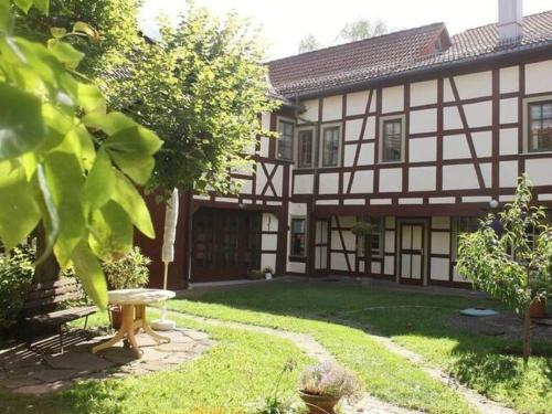 un edificio con un cortile con una panchina di fronte di Apartment in Tabarz Thuringia near the forest a Tabarz