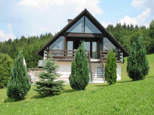 a house in a field with trees in front of it at Holiday home in the Bavarian Forest in Schöfweg