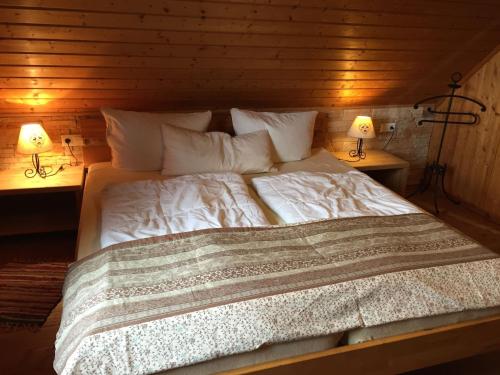 a bed with white sheets and pillows in a room at Magnificent Holiday Home in Reinerzau with Sauna in Alpirsbach