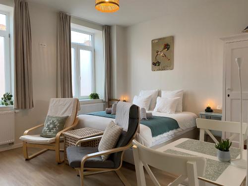 - une chambre avec un lit, une table et des chaises dans l'établissement LOGIES-M Comfort Studios Inc Bikes B&B, à Ostende
