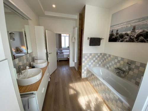 uma casa de banho com 2 lavatórios e uma banheira em LOGIES-M Comfort Studios Inc Bikes B&B em Oostende