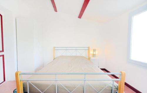 - une chambre avec un lit dans un mur blanc dans l'établissement 3 Bedroom Stunning Home In Théziers, à Théziers