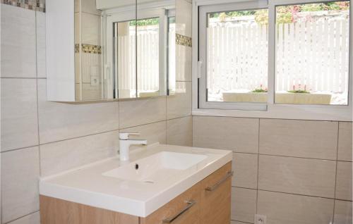 a bathroom with a white sink and a mirror at Lovely Home In Plévenon Cap Fréhel in Plévenon