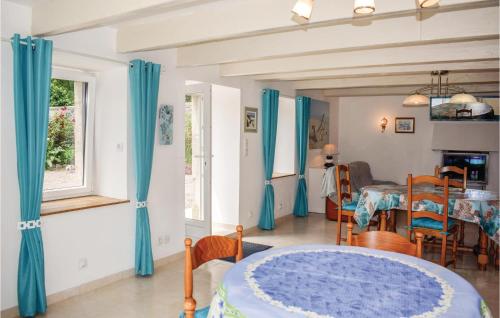 a living room with blue curtains and a table at Lovely Home In Plévenon Cap Fréhel in Plévenon
