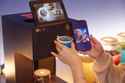 a woman taking a picture of a coffee machine at Rembrandt Cabin Shinjuku Shin-Okubo in Tokyo
