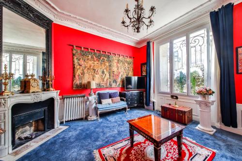 Elle comprend un salon doté de murs rouges et d'une cheminée. dans l'établissement #Arc DeTriomphe #Trocadero #Style Haussmanien#AC, à Paris