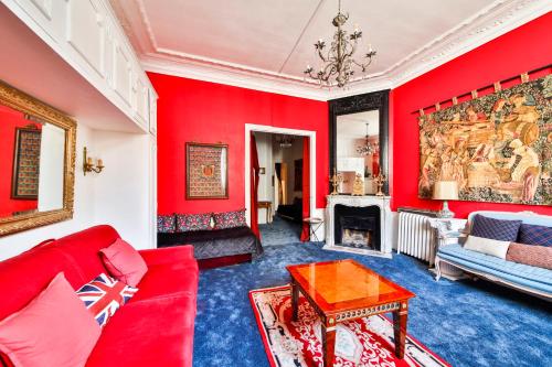 - un salon avec des murs rouges et un canapé rouge dans l'établissement #Arc DeTriomphe #Trocadero #Style Haussmanien#AC, à Paris