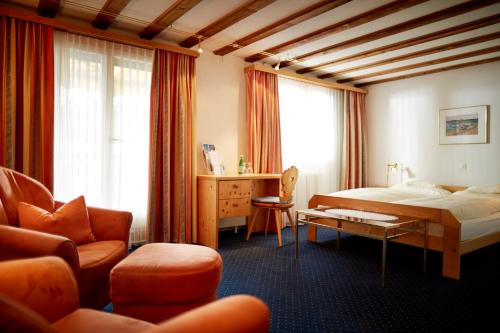 ダボスにあるCasanna Hotel Davos City Centerのベッドとデスクが備わるホテルルームです。