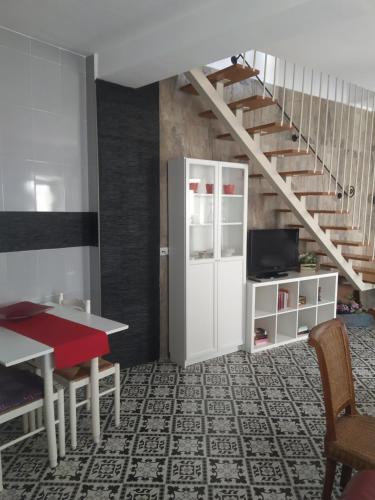 uma sala de estar com uma mesa vermelha e uma escada em Casa rural Hnas Corral em Almoharín
