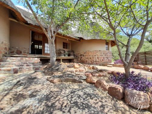 a stone house with trees in front of it at Moritshane estate in Gaborone