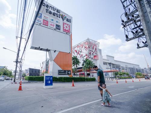 a man and a little girl standing in the street at Hybrit hostel&cafe in Hat Yai