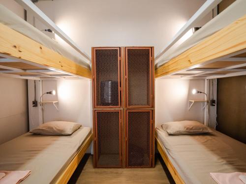two beds in a room with two bunk beds at Hybrit hostel&cafe in Hat Yai