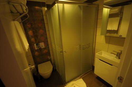 a bathroom with a shower and a toilet and a sink at Aura Boutique Hotel in Side
