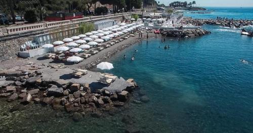 a pool with umbrellas and people in the water at Hotel Kristina in Imperia