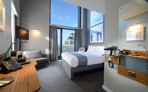 Pokój hotelowy z łóżkiem i biurkiem w obiekcie Travelodge PLUS Dublin City Centre w Dublinie