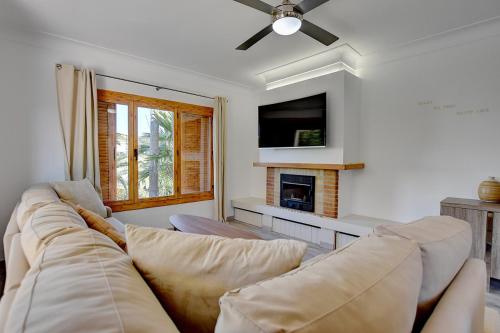 a living room with a couch and a tv at Villa Maravillas 2 by Slow Villas in El Arenal