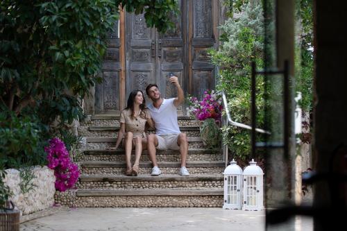 a man and a woman sitting on the stairs at Peninsula Gardens Hotel in Kas