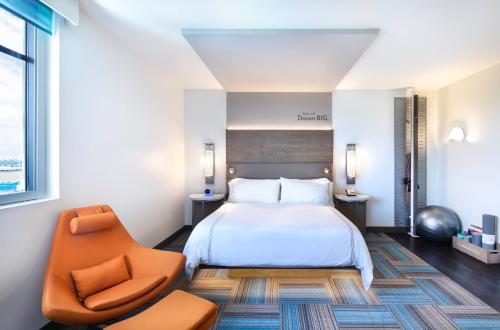 a hotel room with a bed and a chair at EVEN Hotel Miami - Airport by IHG in Miami