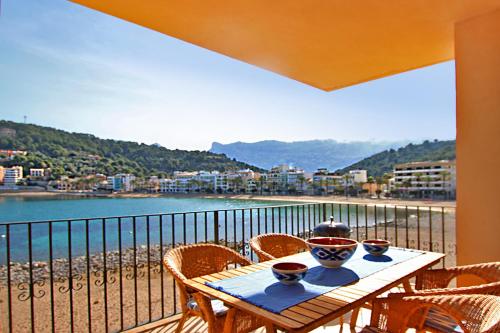 a table with bowls and chairs on a balcony at Es Faro House by Slow Villas in Port de Soller