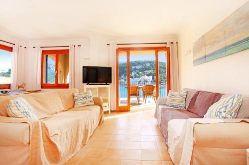 un soggiorno con 2 divani e una TV di Es Faro House by Slow Villas a Port de Sóller