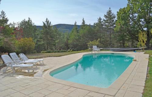 a swimming pool with two chairs and a table at Amazing Home In La Bastide With 5 Bedrooms And Outdoor Swimming Pool in La Bastide