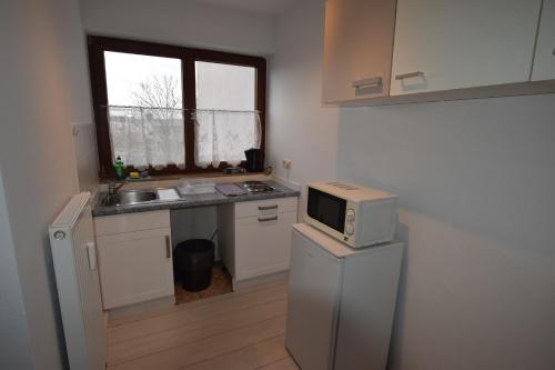 a kitchen with a microwave on top of a refrigerator at AB Apartment Waiblingen in Waiblingen