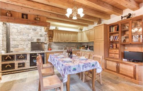 a kitchen with a table and chairs and a stone wall at Alle Sorgenti in Comeglians