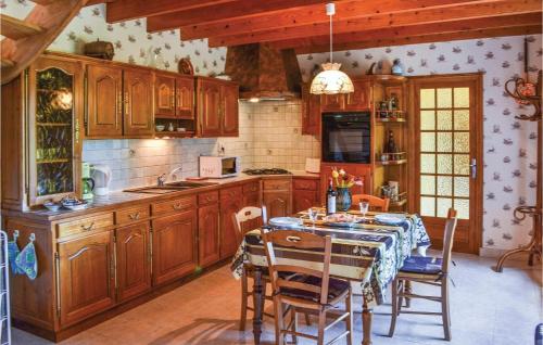 une cuisine avec des armoires en bois et une table avec des chaises dans l'établissement 3 Bedroom Lovely Home In Plouha, à Plouha