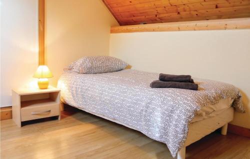 - une chambre avec un lit et une table de nuit avec une lampe dans l'établissement Stunning Home In Brucheville With Wifi, à Brucheville